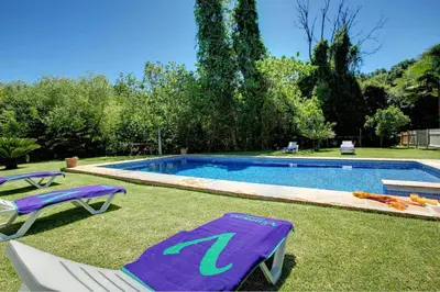 a swimming pool with two lawn chairs and a purple towel at El Molino del Pilón by Vintage Travel in Arcos de la Frontera