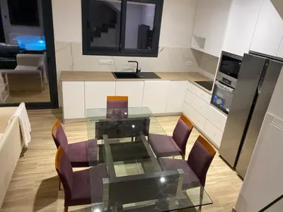 a kitchen with a glass table and some chairs at Cadiz Golf & Homework in Puerto Real