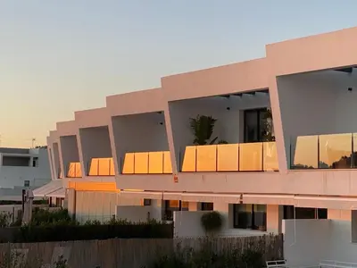 a large pink building with a sunset in the background at Cadiz Golf & Homework in Puerto Real