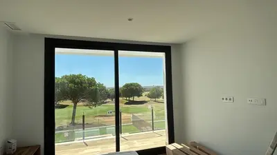 a room with a large window with a view of a park at Cadiz Golf & Homework in Puerto Real