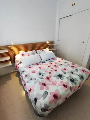 a bedroom with a bed with flowers on it at Piso a estrenar en el pintoresco Barrio Alto in Sanlúcar de Barrameda