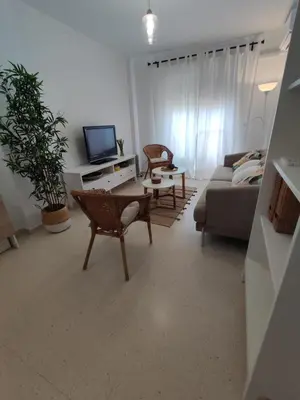 a living room with a couch and a tv at Piso a estrenar en el pintoresco Barrio Alto in Sanlúcar de Barrameda