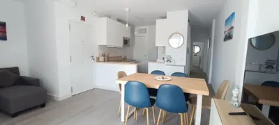 a kitchen and dining room with a table and blue chairs at Villa Brinco in Chipiona