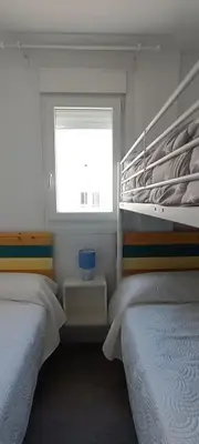 a bedroom with two twin beds and a window at Villa Brinco in Chipiona