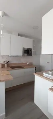 a kitchen with white cabinets and a wooden counter top at Villa Brinco in Chipiona