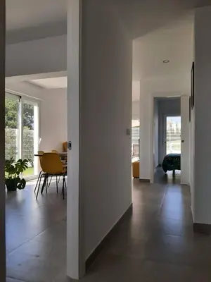 a living room with a table and a dining room at Casa Rosado Beautiful House and 60 m of Private Garden in Conil de la Frontera