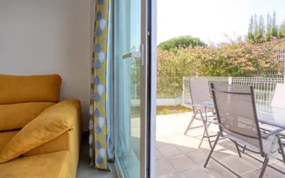 a living room with a couch and a table and chairs at Casa Rosado Beautiful House and 60 m of Private Garden in Conil de la Frontera