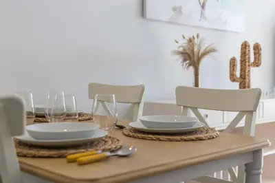 a dining room table with plates and glasses on it at Holiday Homes - Los Ángeles de Costa Ballena in Chipiona