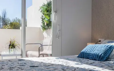 a bedroom with a bed and a chair and a window at Holiday Homes - Los Ángeles de Costa Ballena in Chipiona