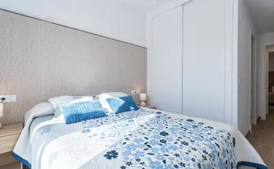 a bedroom with a large bed with blue pillows at Holiday Homes - Los Ángeles de Costa Ballena in Chipiona