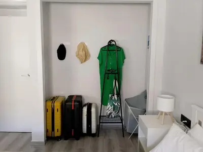 a room with luggage and a green coat on a wall at Light and spacious apartment in the heart of San Fernando, Cádiz in San Fernando