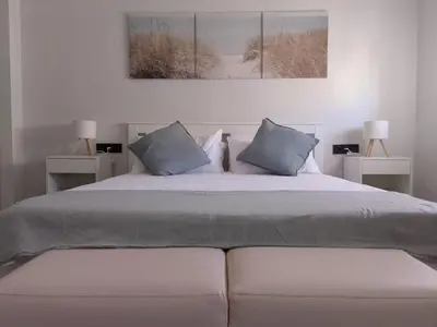 a bedroom with a large bed with two night stands at Light and spacious apartment in the heart of San Fernando, Cádiz in San Fernando