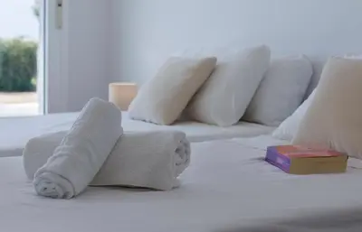 a white bed with towels and a book on it at Holiday Homes - Ocean Costa Ballena in Cádiz