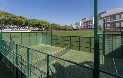 a tennis court with a tennis net on a court at Holiday Homes - Ocean Costa Ballena in Cádiz
