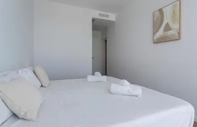 a white bed with two white towels on it at Holiday Homes - Ocean Costa Ballena in Cádiz