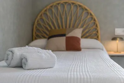 a bed with a white towel on top of it at Holiday Homes - Sky Garden Jerez in Jerez de la Frontera