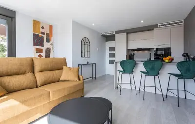 a living room with a couch and a kitchen at Holiday Homes - Sky Garden Jerez in Jerez de la Frontera