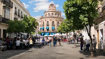 a crowd of people walking down a street with a building at Holiday Homes - Sky Garden Jerez in Jerez de la Frontera