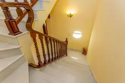a staircase in a home with a wooden railing at Villa Stella maison entre Séville et Cadix in Lebrija