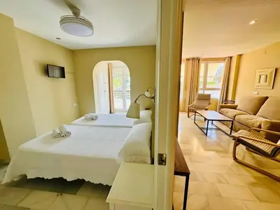 a bedroom with a large bed and a living room at Apartamento Vista Hermosa Grupo AC Gestion in El Puerto de Santa María