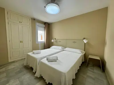 a bedroom with two beds with white sheets at Apartamento Vista Hermosa Grupo AC Gestion in El Puerto de Santa María