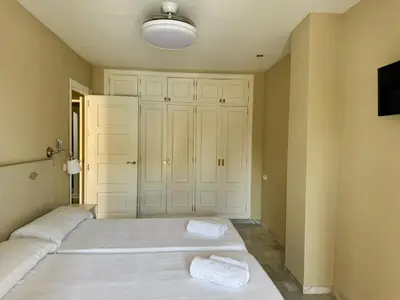 a bedroom with two beds and a tv at Apartamento Vista Hermosa Grupo AC Gestion in El Puerto de Santa María