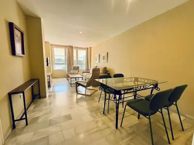 a living room with a table and chairs at Apartamento Vista Hermosa Grupo AC Gestion in El Puerto de Santa María