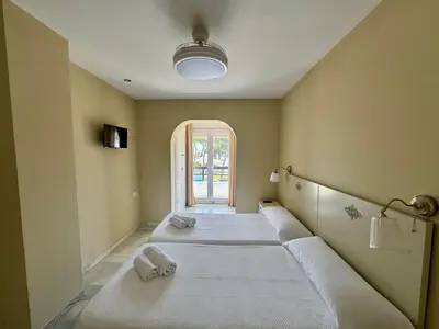 a room with three beds in it with a window at Apartamento Vista Hermosa Grupo AC Gestion in El Puerto de Santa María