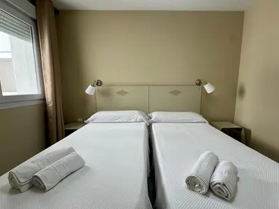 a bedroom with two beds with towels on them at Apartamento Vista Hermosa Grupo AC Gestion in El Puerto de Santa María
