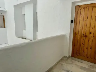 a white room with a mirror and a wooden door at Apartamento Vista Hermosa Grupo AC Gestion in El Puerto de Santa María