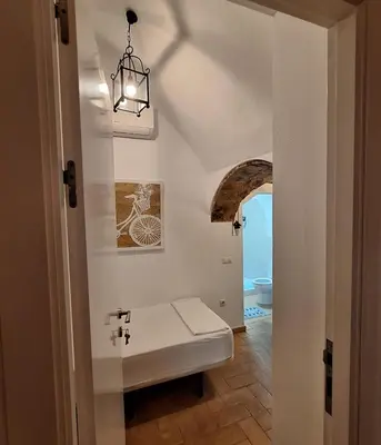 a white room with a bench in a hallway at Habitación con baño privado in Sanlúcar de Barrameda