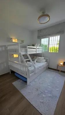 a bedroom with two white bunk beds and a rug at Blue Moon House Costa Ballena by Sanlúcar Housing in Costa Ballena