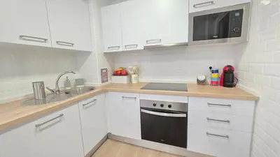 a kitchen with white cabinets and a black appliance at Blue Moon House Costa Ballena by Sanlúcar Housing in Costa Ballena