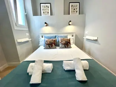 a bedroom with a large white bed with two pillows at GATU Coqueto in El Puerto de Santa María