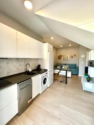 a kitchen with white cabinets and a washer and dryer at GATU Coqueto in El Puerto de Santa María
