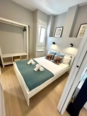 a bedroom with a large bed with towels on it at GATU Coqueto in El Puerto de Santa María