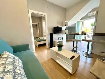 a living room with a blue couch and a table at GATU Coqueto in El Puerto de Santa María