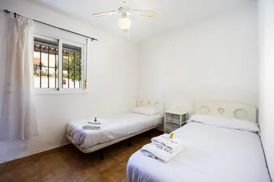 a bedroom with a bed with a ceiling fan at Atlantic Sun Villa - Chiclana in Chiclana de la Frontera