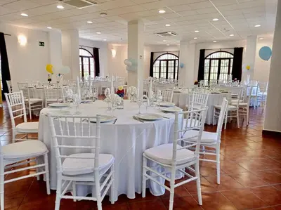 a room with tables and chairs with white tablecloths at Hotel Tugasa Villa de Algar in Algar
