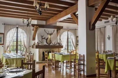 a dining room with green tables and chairs and windows at Hotel Tugasa Villa de Algar in Algar