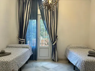 a bedroom with two beds and a window at Chalet San Francisco in Sanlúcar de Barrameda