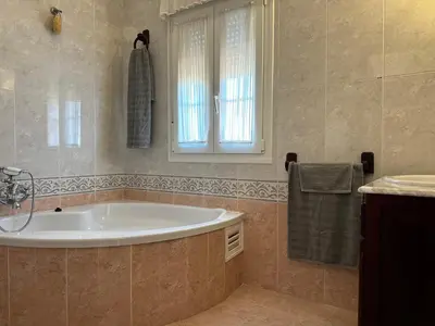 a bathroom with a tub and a window and a sink at Chalet San Francisco in Sanlúcar de Barrameda