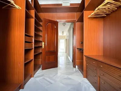 a walk in closet with wooden cabinets and a door at Chalet San Francisco in Sanlúcar de Barrameda