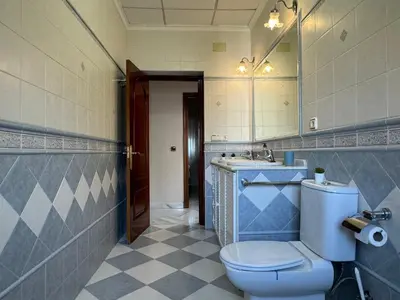a bathroom with a toilet and a sink and a mirror at Chalet San Francisco in Sanlúcar de Barrameda