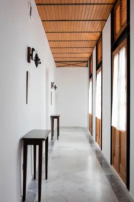 a hallway with wooden ceilings and tables in a room at Hotel Tugasa Casa Palacio Medina Sidonia in Medina Sidonia