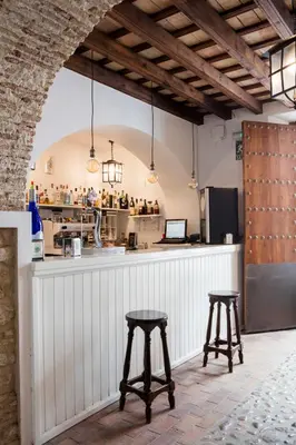 a kitchen with two bar stools and a counter at Hotel Tugasa Casa Palacio Medina Sidonia in Medina Sidonia