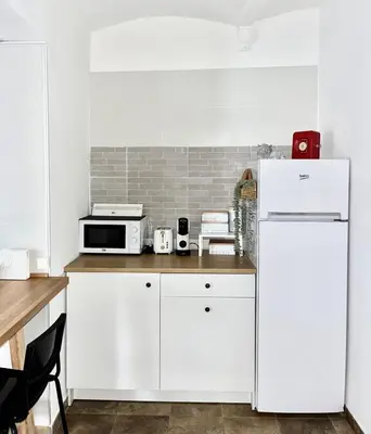 a kitchen with white cabinets and a white refrigerator at Apartamento en El Puerto de Santa María in El Puerto de Santa María
