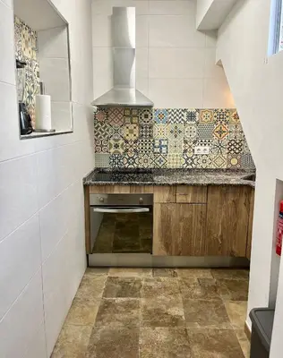 a kitchen with a stove and a tile wall at Apartamento en El Puerto de Santa María in El Puerto de Santa María