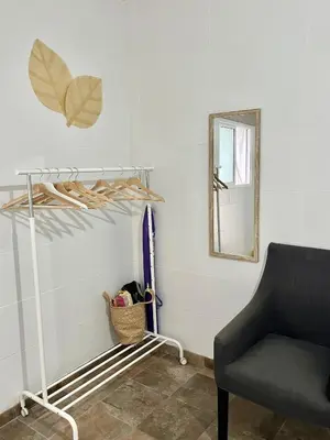 a living room with a chair and a mirror at Apartamento en El Puerto de Santa María in El Puerto de Santa María