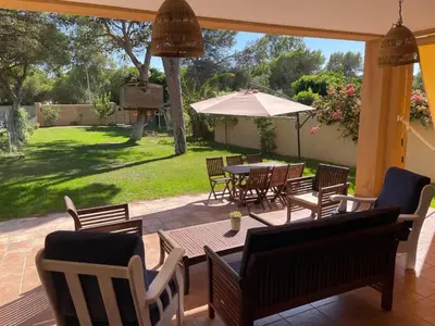 a patio with a table and chairs and an umbrella at Casa Savile in Novo Sancti Petri